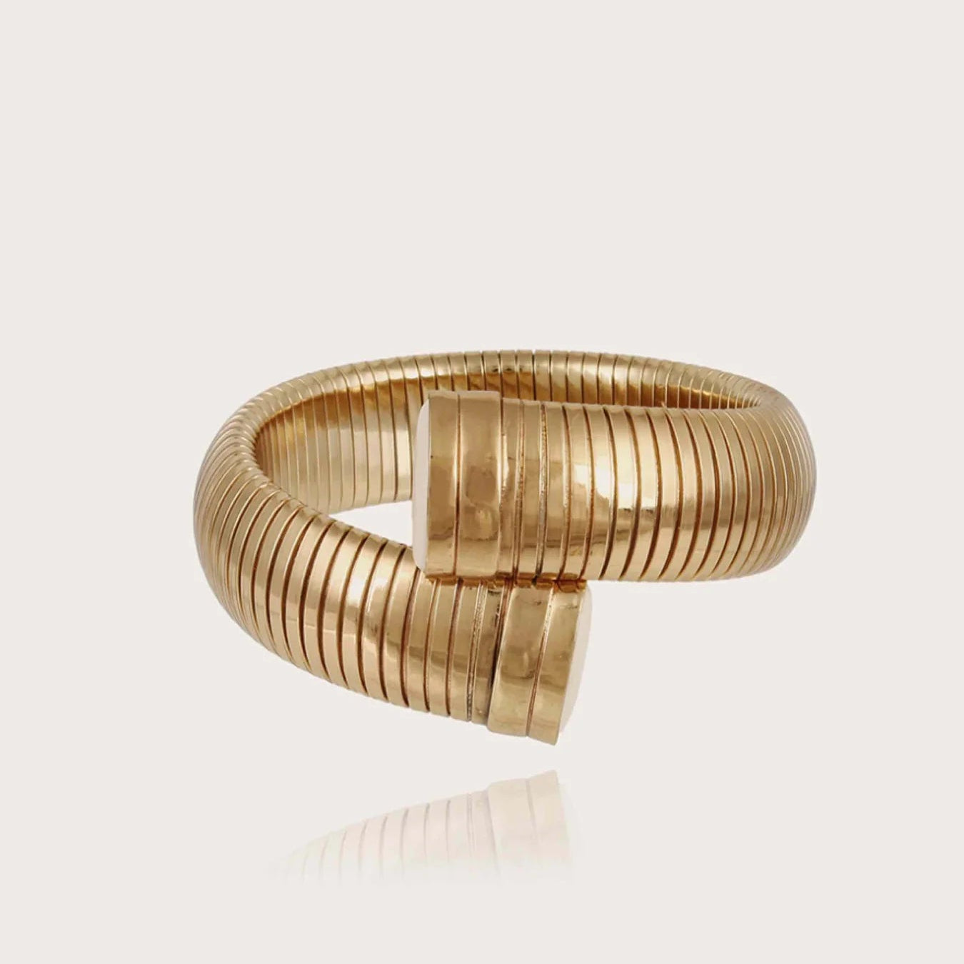 Gold bracelet on a light beige background